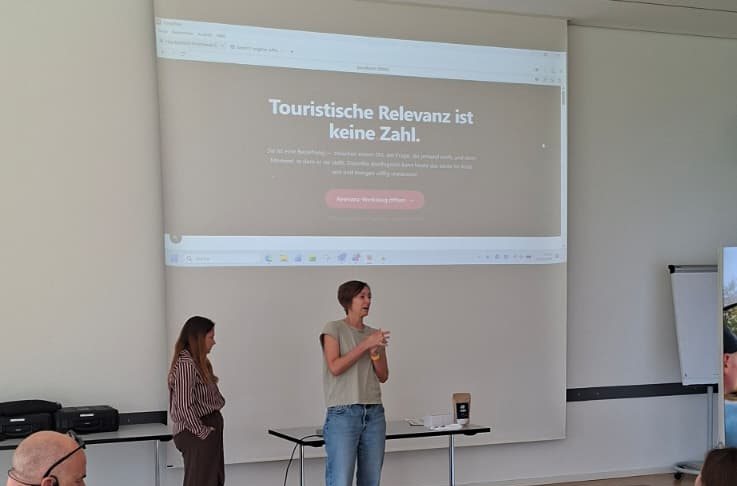 Zwei Teilnehmerinnen stellen vor der Leinwand ihren Prototyp vor