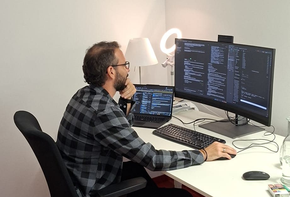 Teilnehmer am Schreibtisch, auf dem Bildschirm ein Arbeitsablauf im Editor
